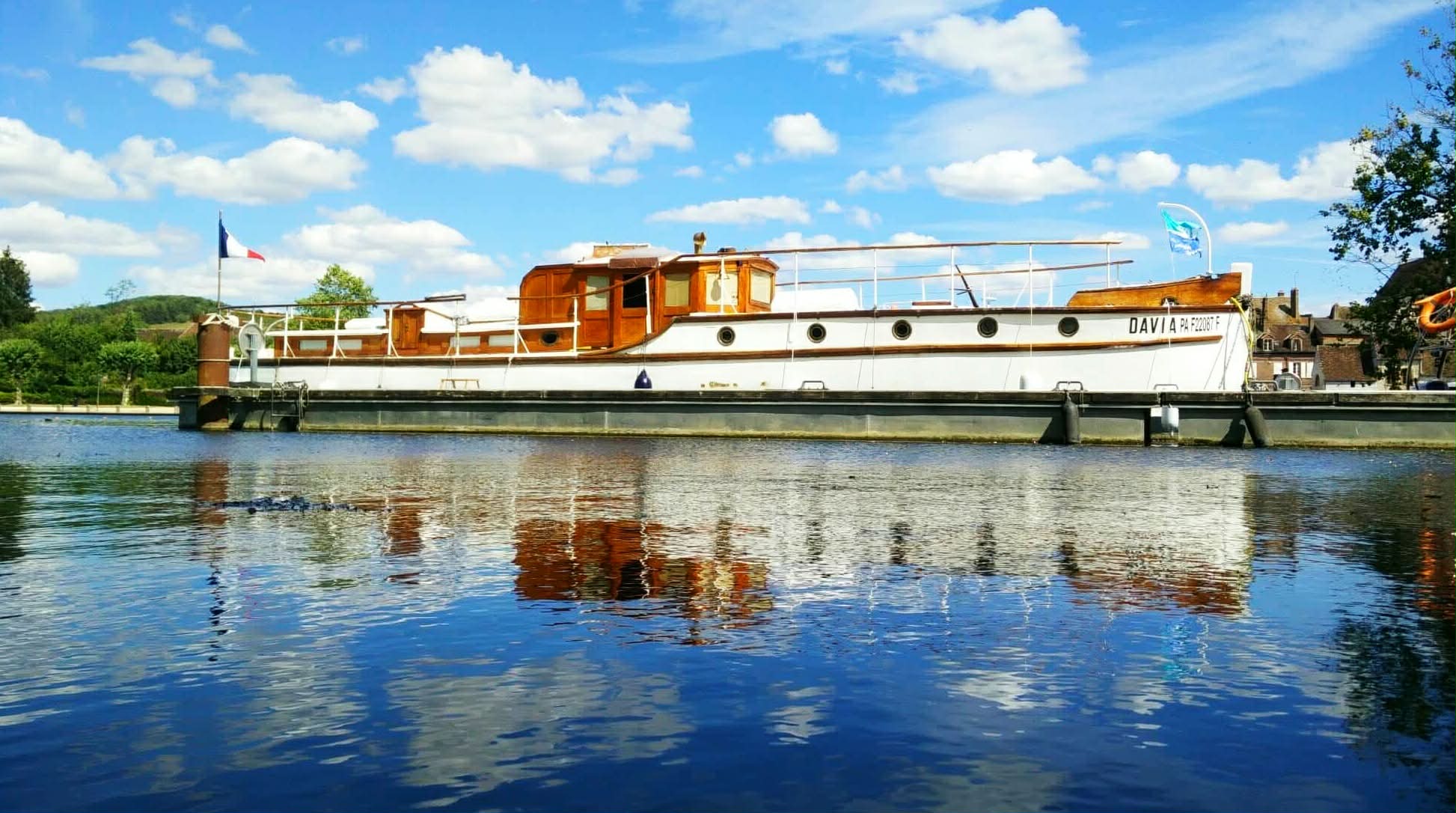 Le Davia amarré au ponton de Villeneuve-sur-Yonne, ciel bleu et reflet sur l'eau