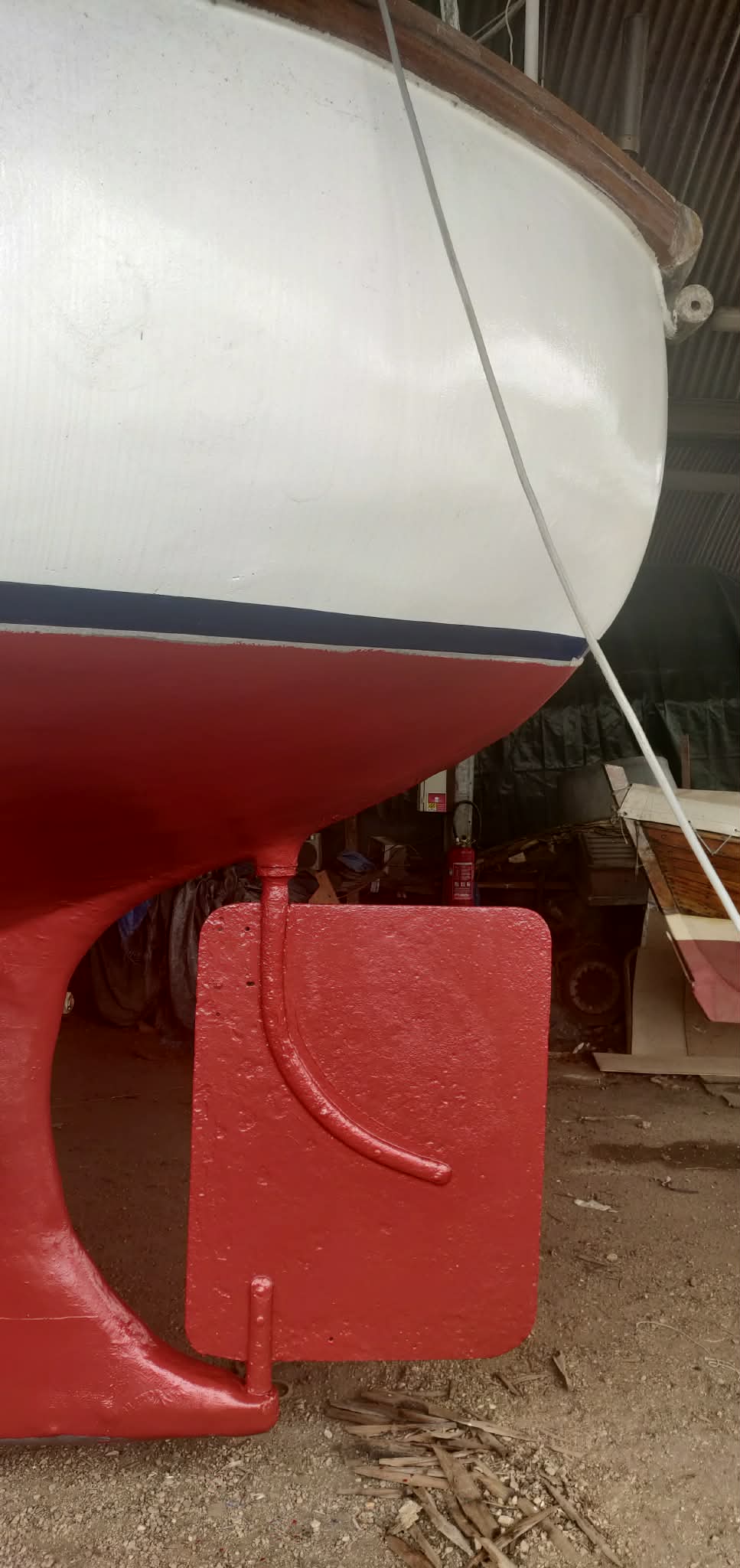 The Davia's red hull and rudder in dry dock during the major refit